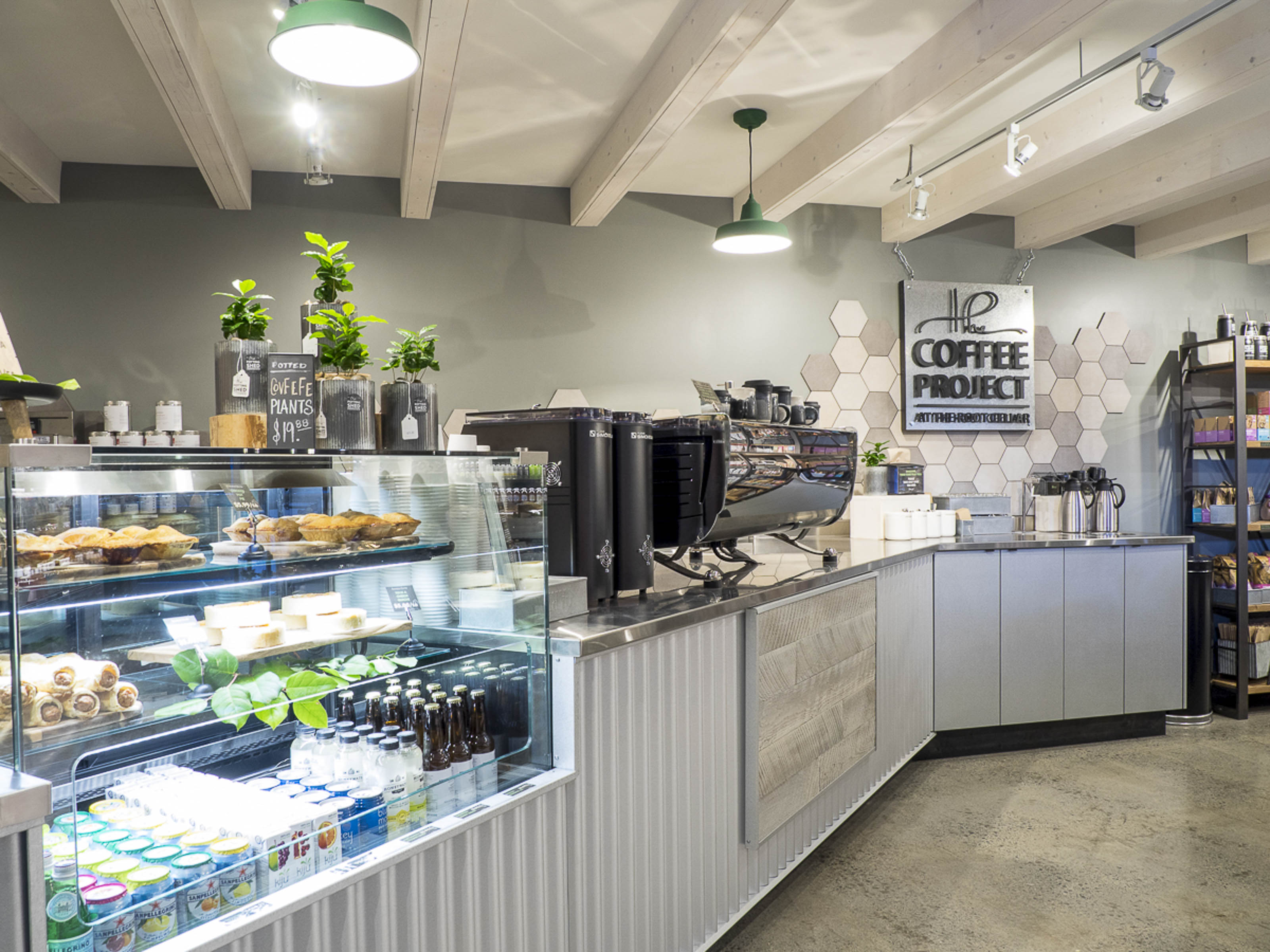 Commercial coffee shop construction Victoria BC - The Coffee Project tenant improvement by Outlook Project Management with exposed beam ceiling, hexagonal tile design, and professional cafe equipment installation