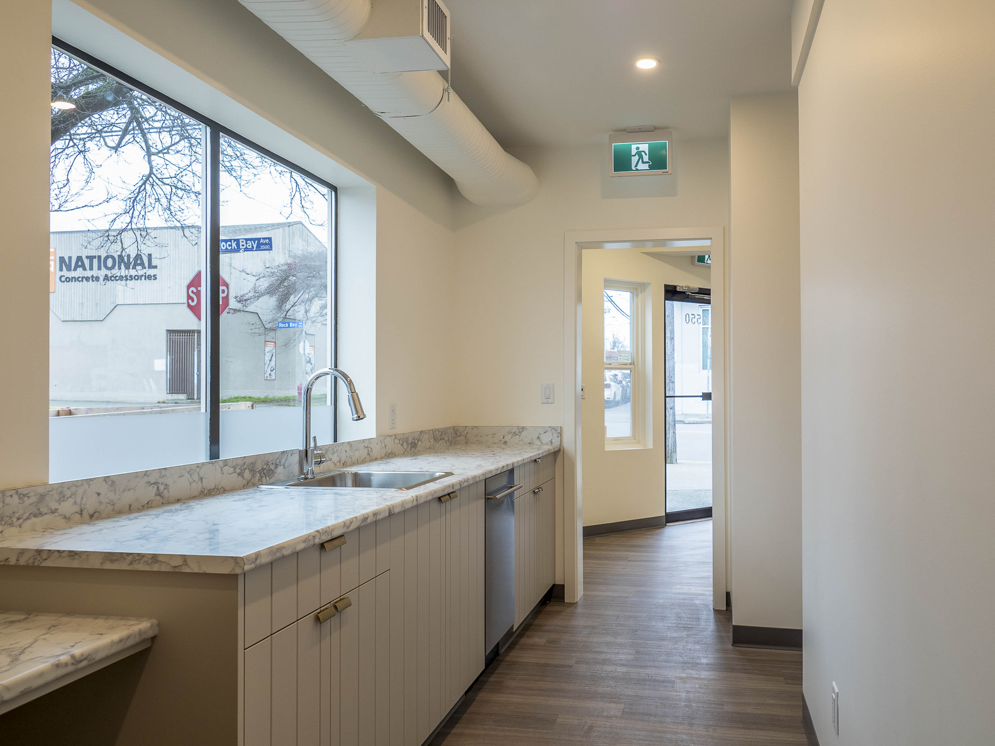 Modern employee kitchen renovation Victoria BC - Outlook Project Management Discovery Coffee warehouse remodel featuring marble countertops, light wood cabinetry, and premium office finishes