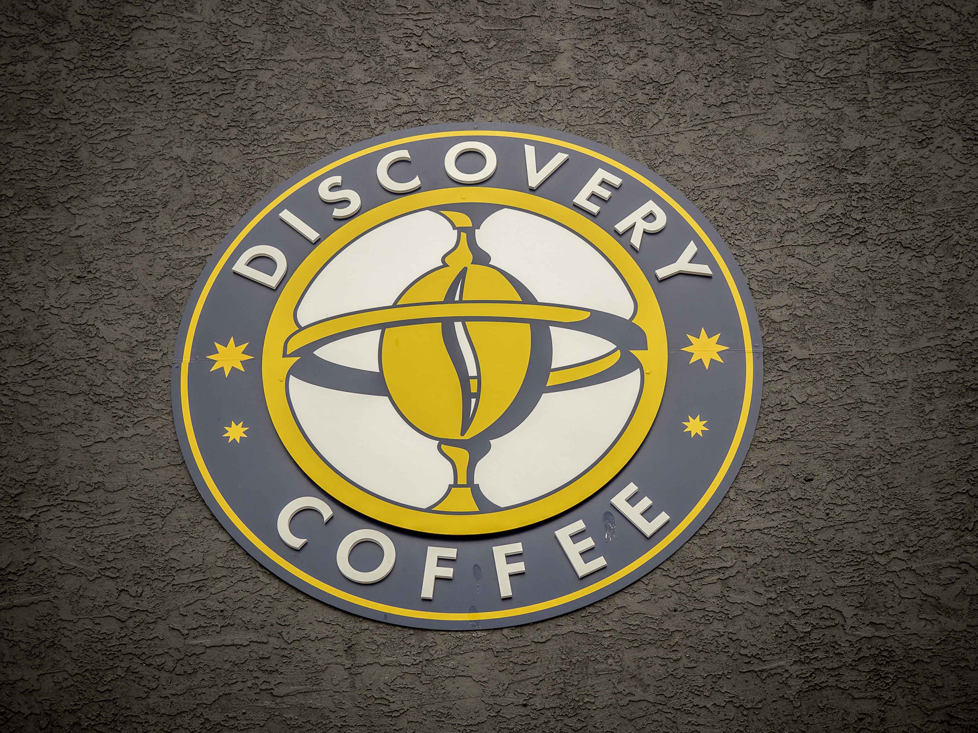 Custom coffee roastery branding Victoria BC - Outlook Project Management Discovery Coffee project featuring professional logo installation and textured wall finishes in warehouse conversion