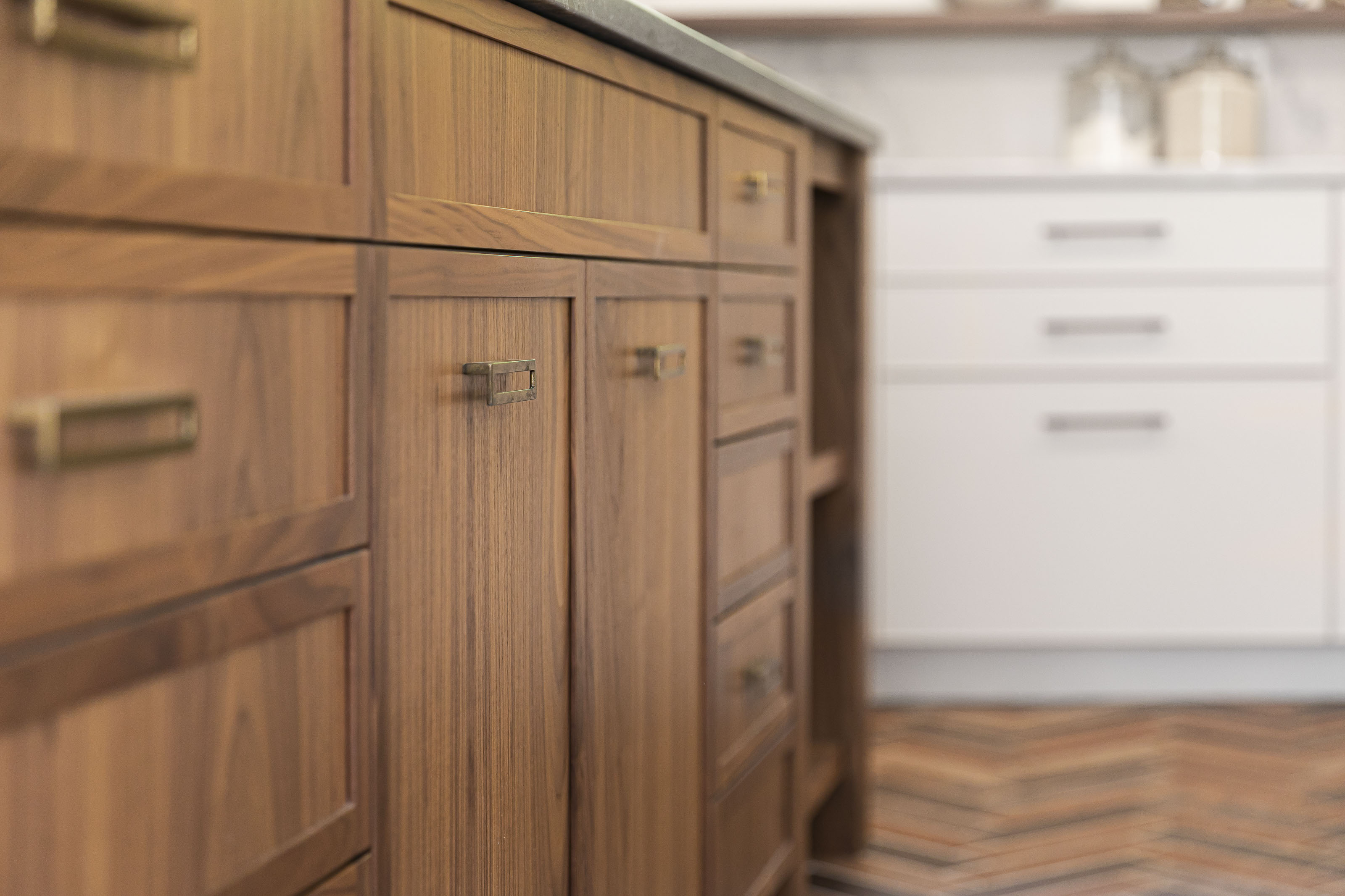 Detailed cabinetry work on walnut kitchen drawers with brass hardware, designed by Outlook Project Management for a residential remodel in Victoria BC.