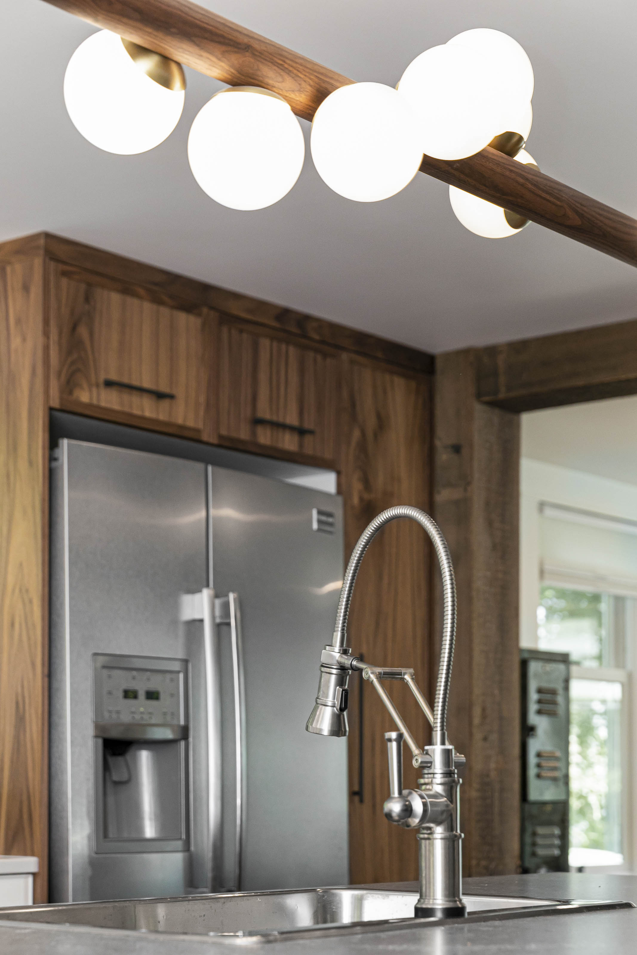 Modern kitchen faucet with pull-down sprayer installed over a stainless steel sink, part of a full kitchen renovation in Victoria by Outlook Project Management.