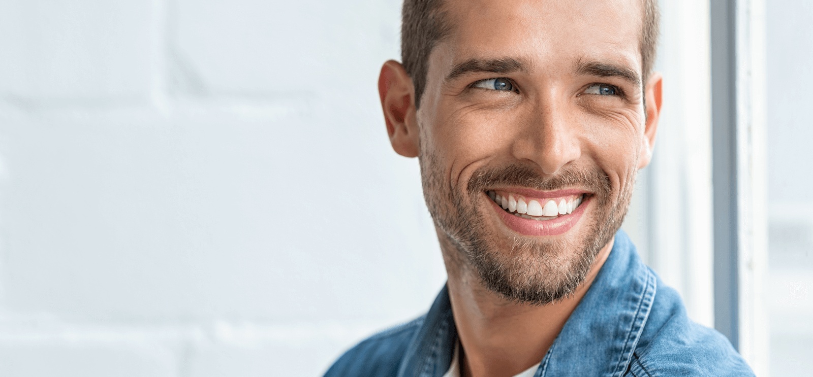 Man smiling confidently with smooth, youthful skin, highlighting results from anti-aging treatments by the best dermatology in Bend, OR.