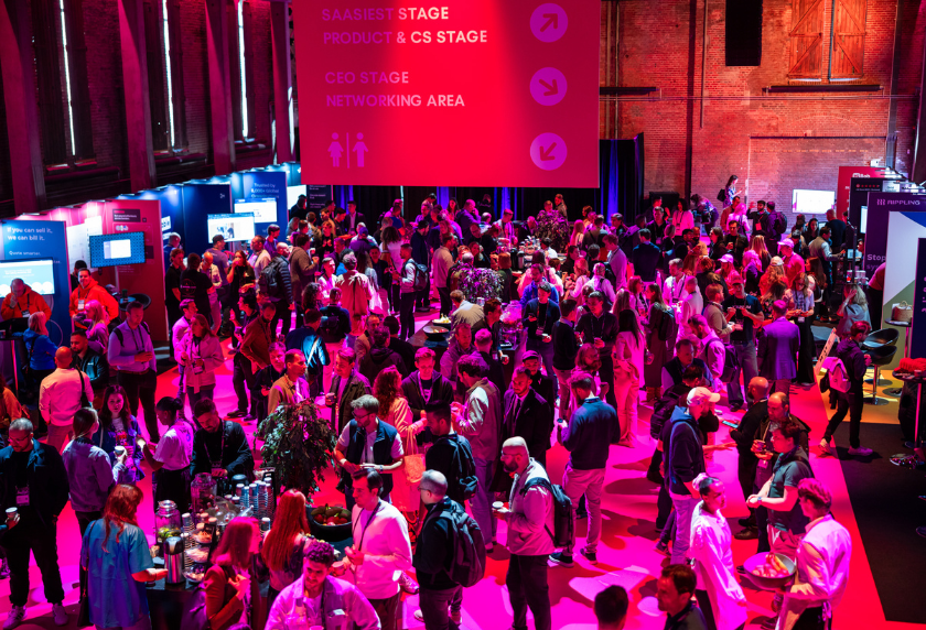 An image from SaaSiest conference, shows people talking in the venue. Illustrates the article: SaaS conferences to attend.