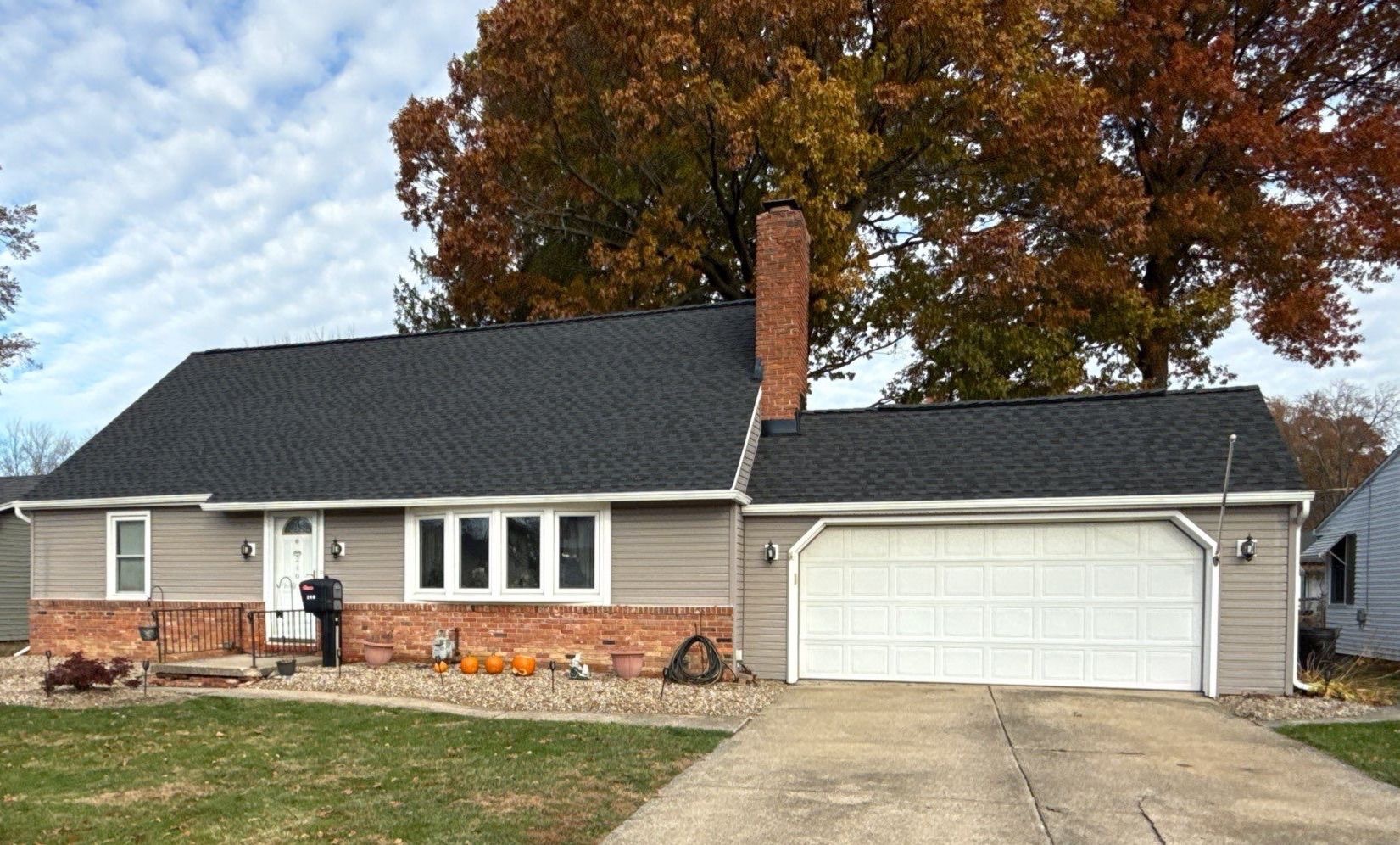 A single-story house with a brick and siding exterior, a garage, and a small decorative garden.