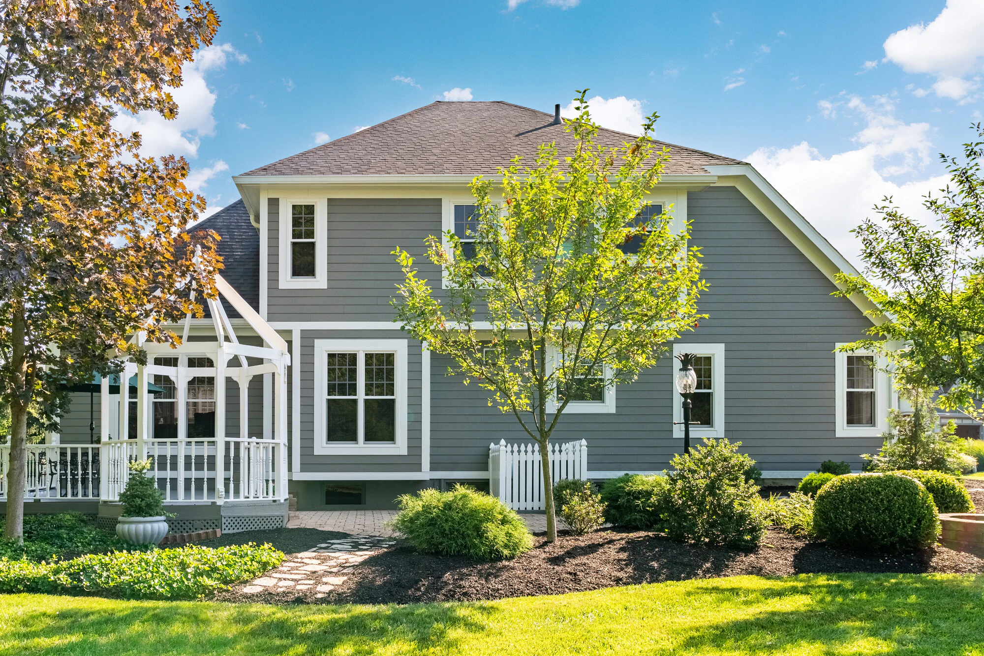 A gray house with a white picket fence.