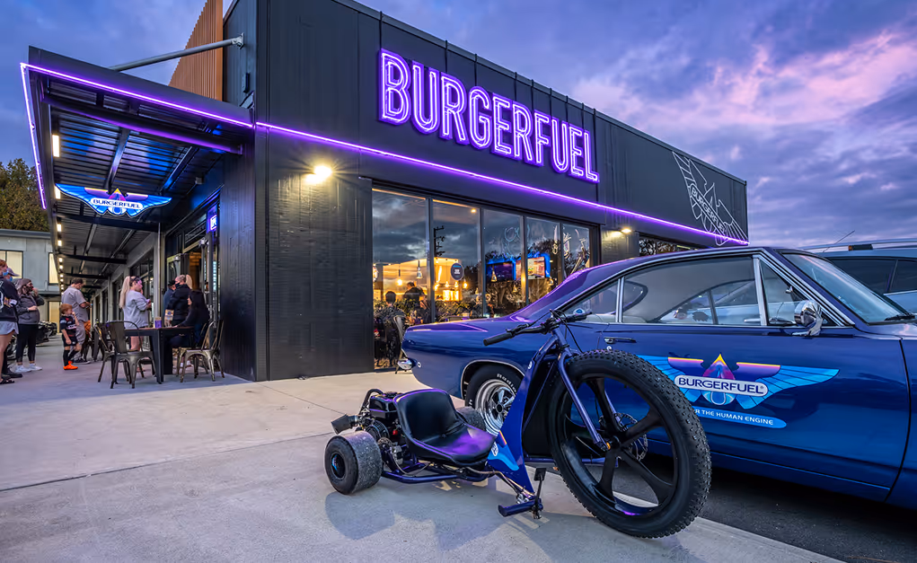 A bike and a car facing towards the outlet of burgerfuel