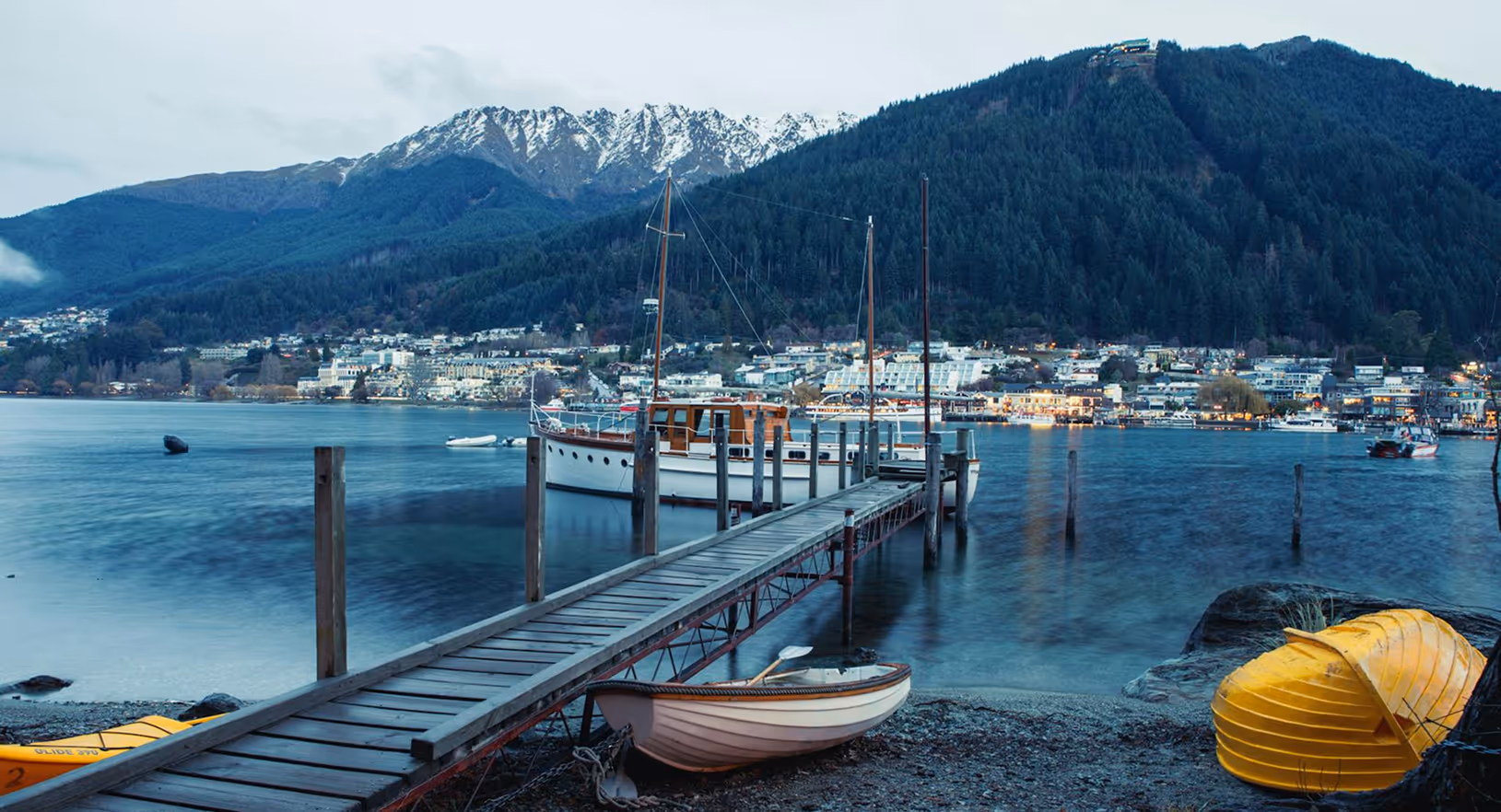 A beautiful bridge over water with mountains in view.