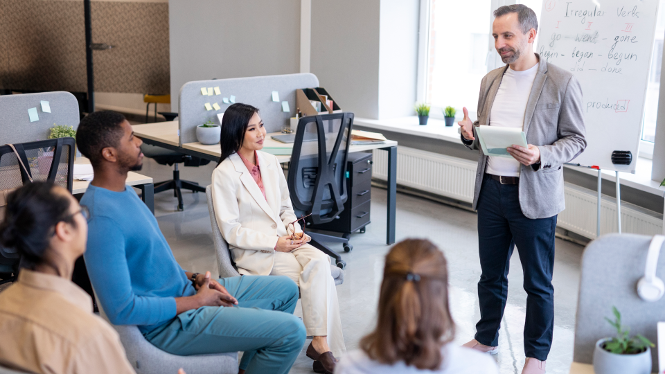 A business professional is speaking to a group of people.