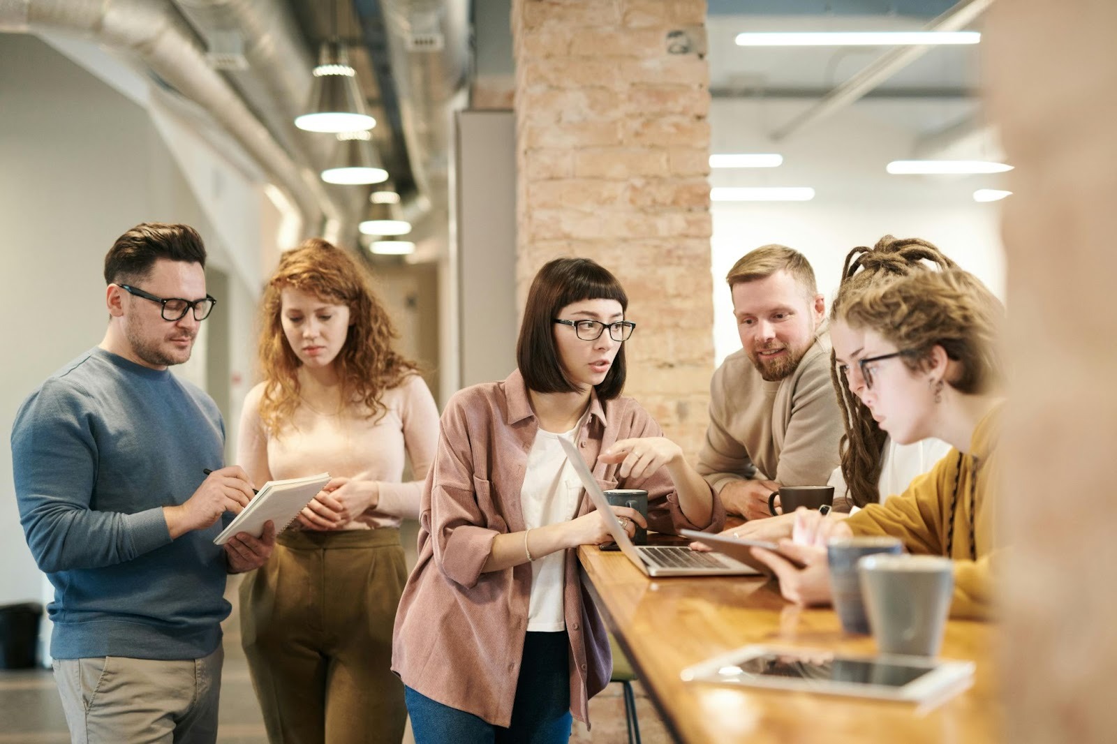 A group of employees collaborating and talking in an office.