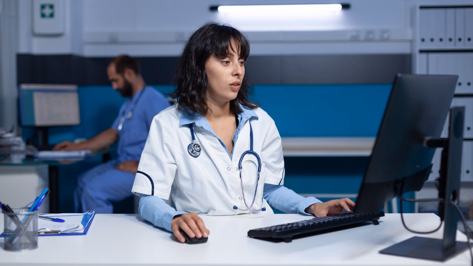 A nurse reviews overtime hours and staffing coverage on a computer during a night shift to support overtime management.