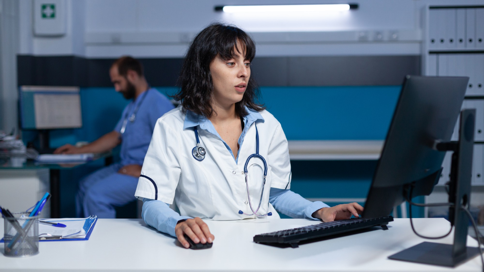  A nurse reviews overtime hours and staffing coverage on a computer during a night shift to support overtime management.