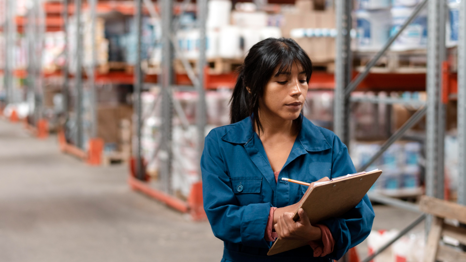  A warehouse worker tracks labor cost metrics on a clipboard to help calculate labor cost and spot cost drift.