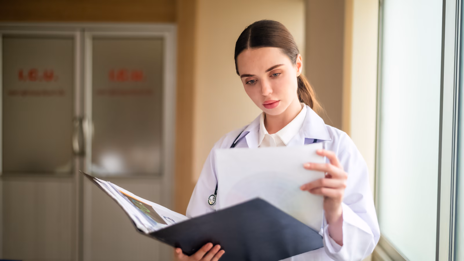  A healthcare worker reviews medical charts to understand causes of absenteeism in the workplace, including illness-related absences.