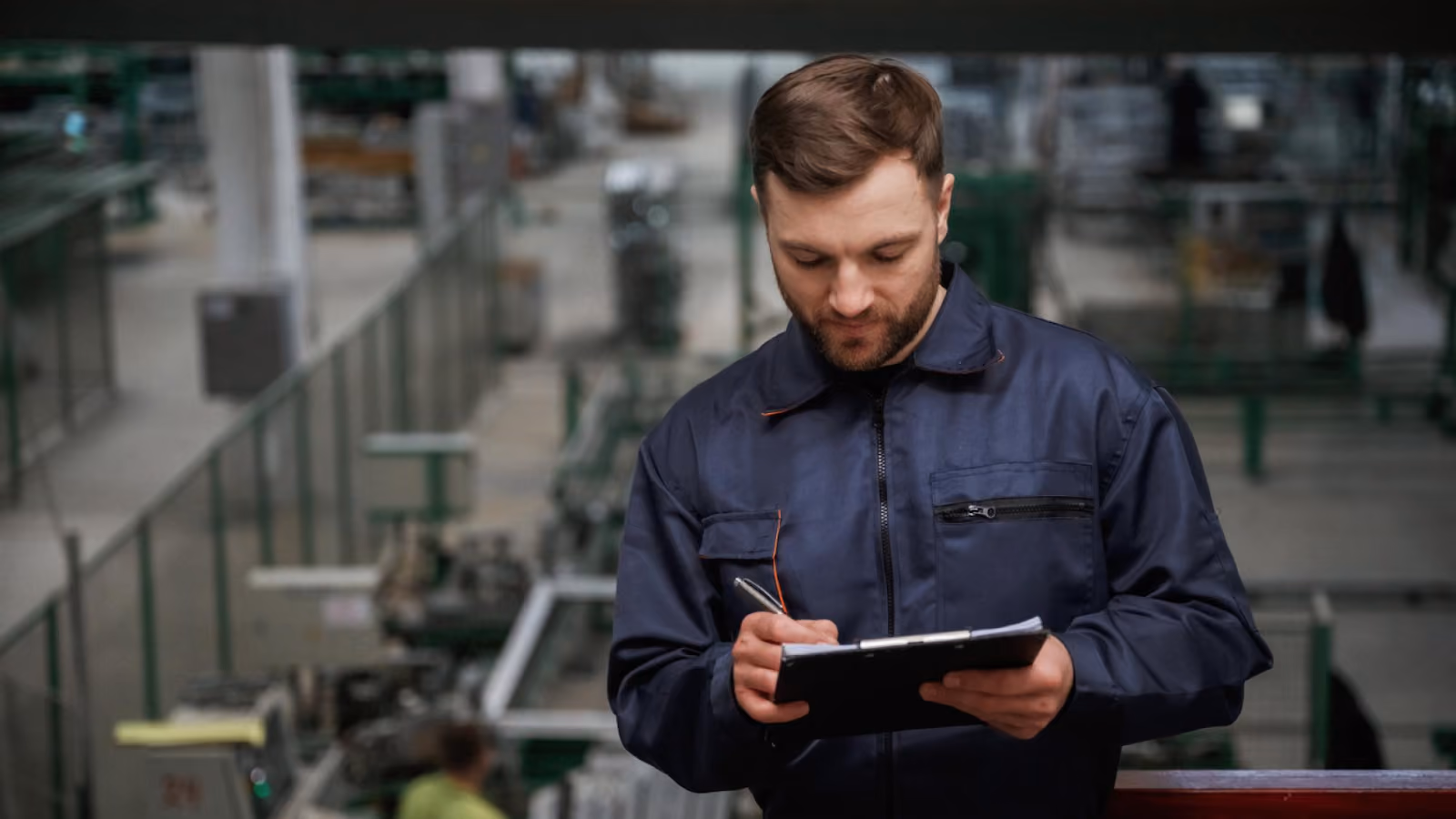  A factory supervisor records workforce data on the floor to apply workforce management best practices and control labor costs.
