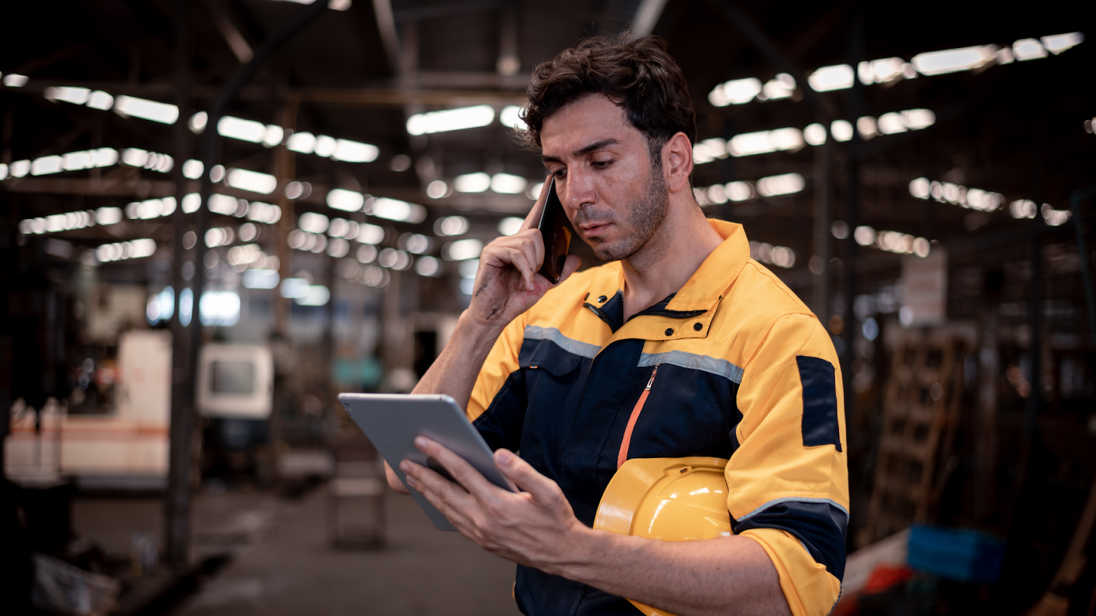 An industrial worker reviewing a 24-hour shift schedule on a tablet to manage 24/7 coverage.