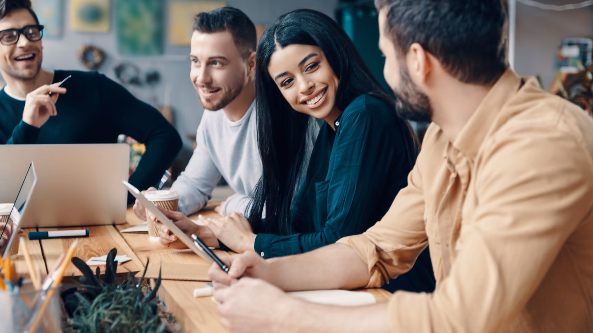 A smiling diverse team discussing shift swap rules by industry during a casual office meeting.
