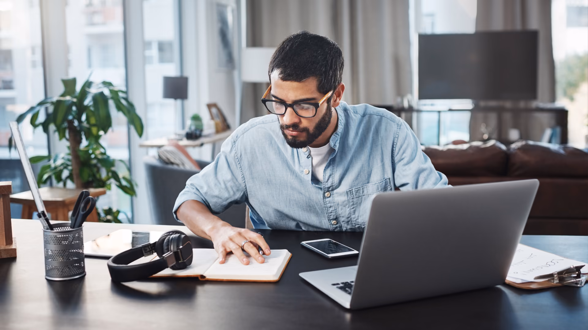 A man in glasses reviews notes, illustrating state employee time card laws and compliance at his desk.