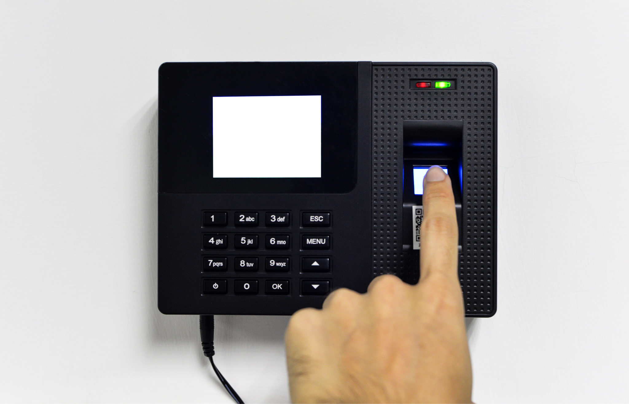 Close-up of a biometric time clock with a fingerprint scanner and numeric keypad in use.
