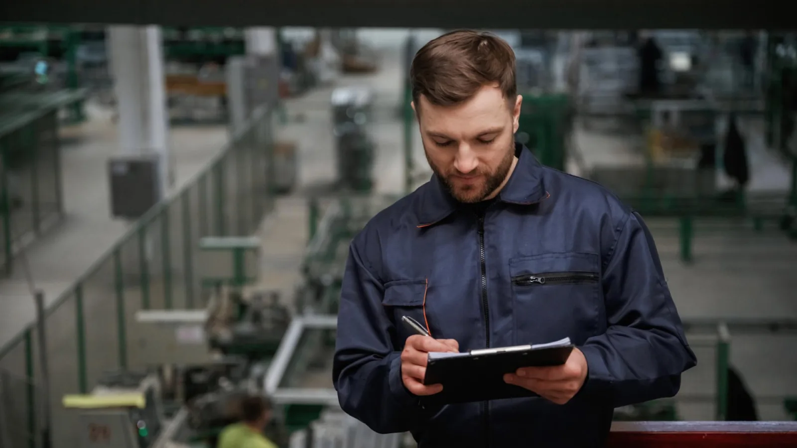 A factory supervisor records workforce data on the floor to apply workforce management best practices and control labor costs.