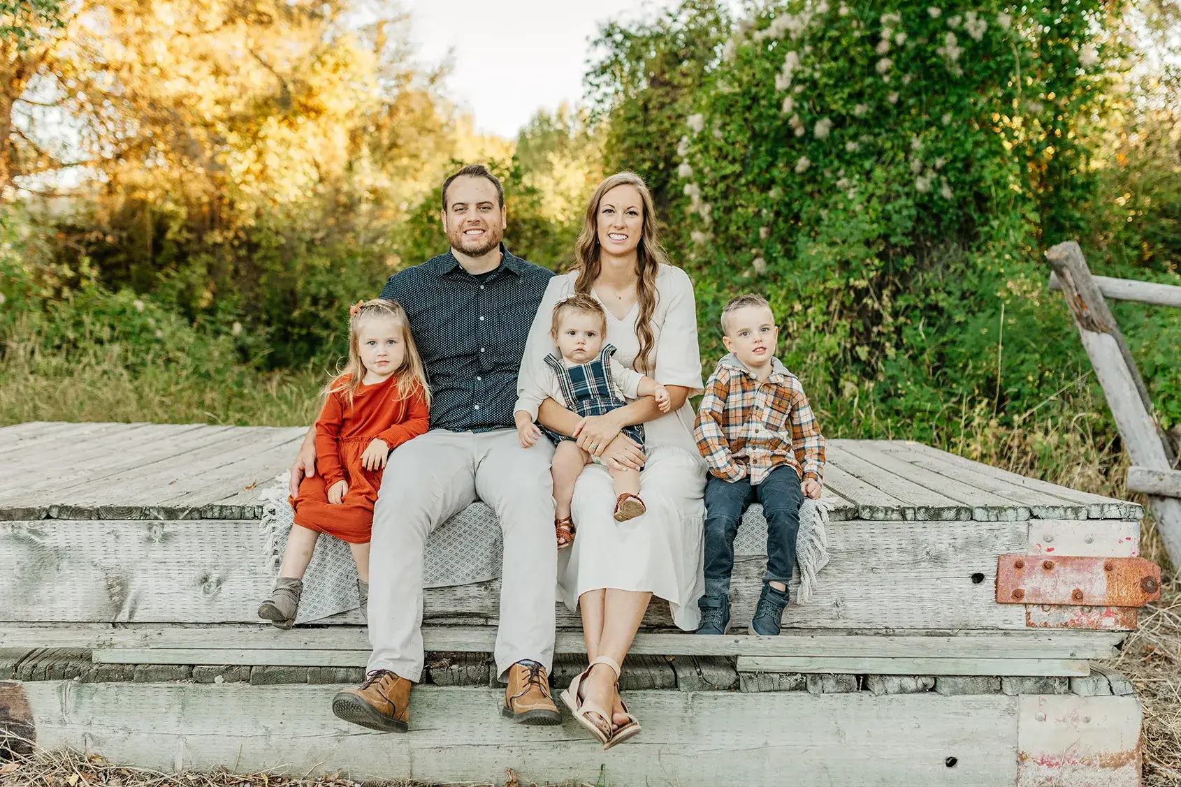 Family photography session at Twin Bridges Campground. There is a family playing with two children. 