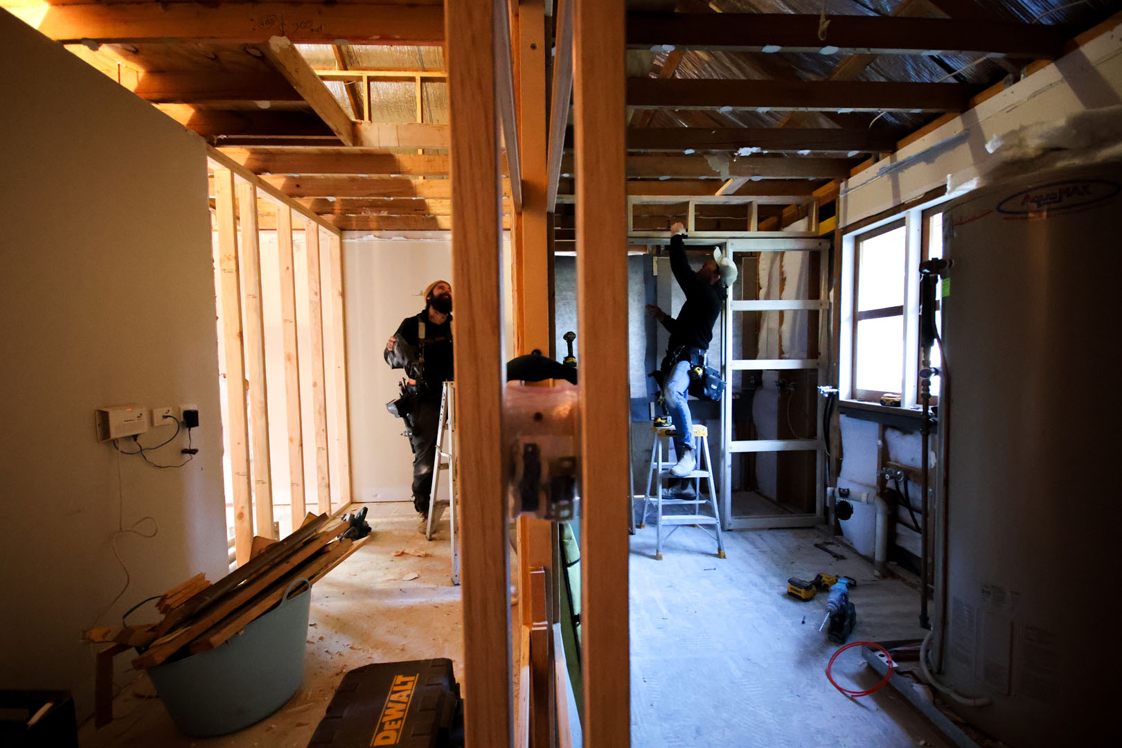 photo of two Nomac Built workers on either side of stud wall