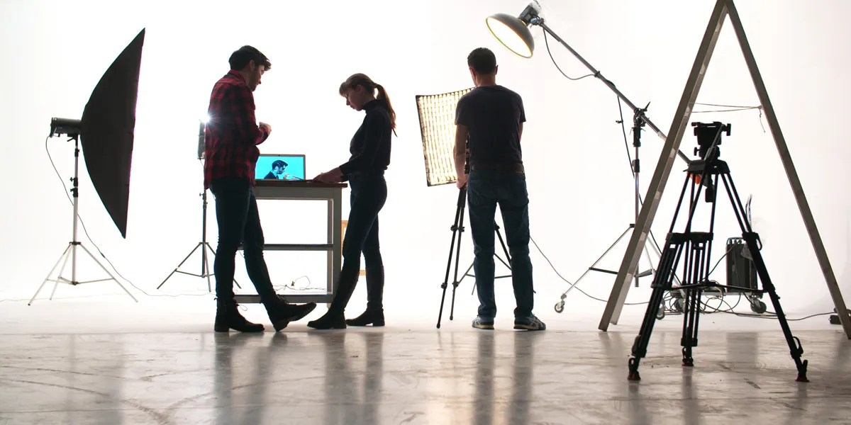 A group of people standing in front of a laptop.
