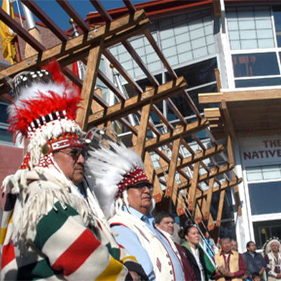 Native American tribe members standing outside of The Payne Family Native American Center located on the University of Montana campus.