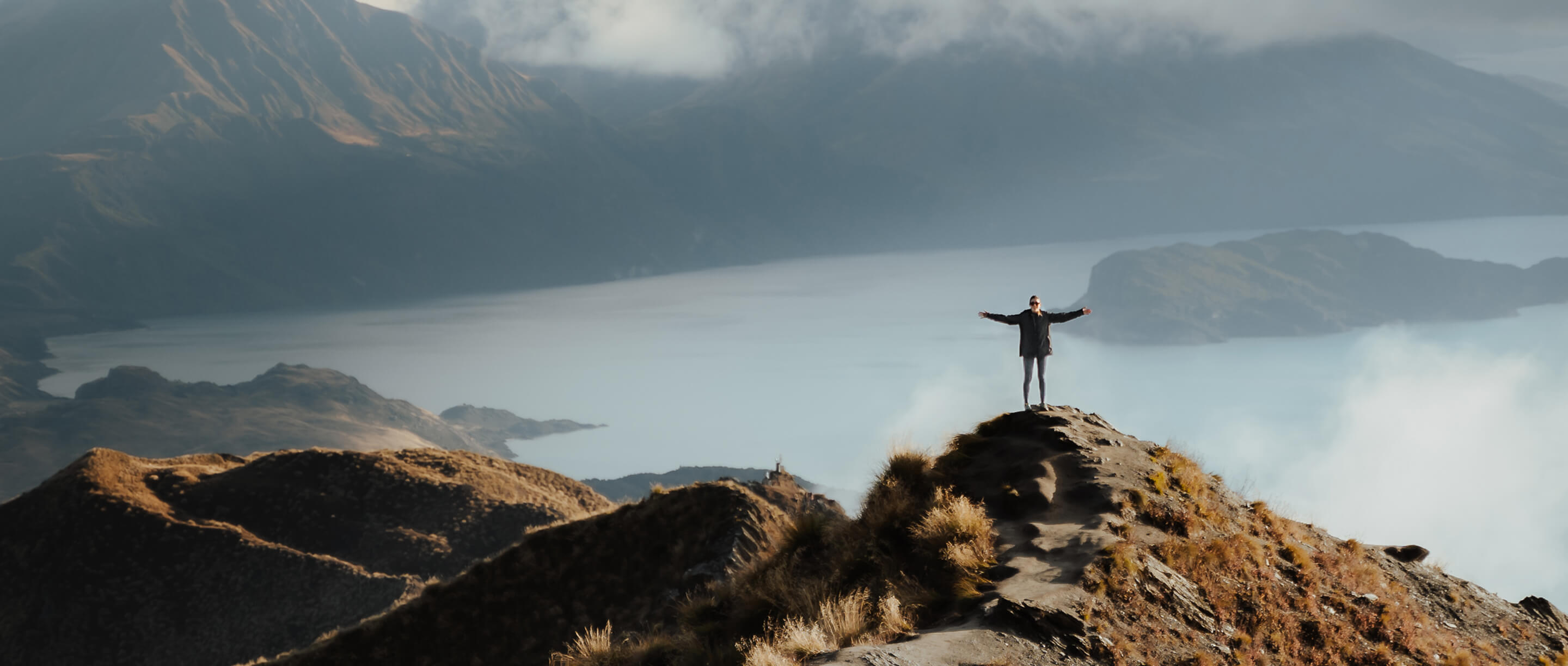 Uplifting mountain landscape with person celebrating – representing freedom, resilience, and mental wellbeing