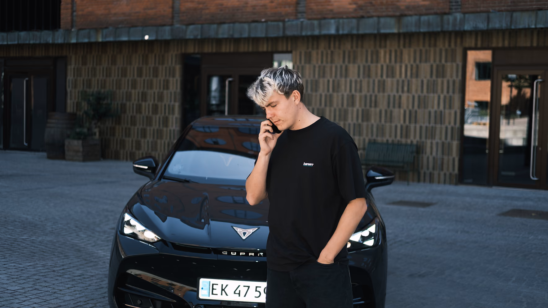 Rasmus foran CUPRA bil og snakker telefon