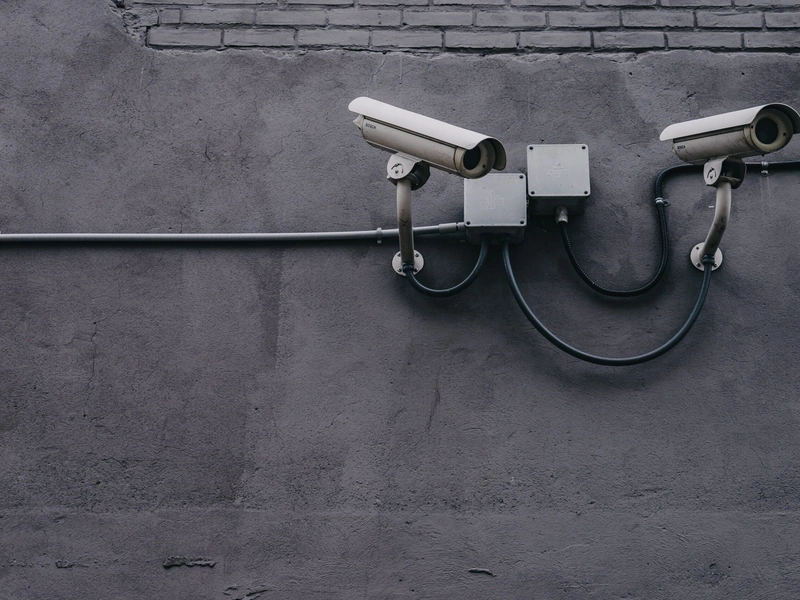 Dos cámaras de seguridad montadas en una pared con cableado visible.