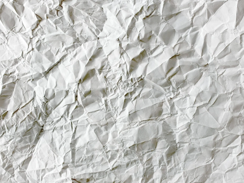 Textura de papel blanco arrugado con pliegues y pliegues irregulares.