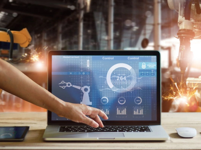 Persona que interactúa con una computadora portátil que muestra un software de control industrial.