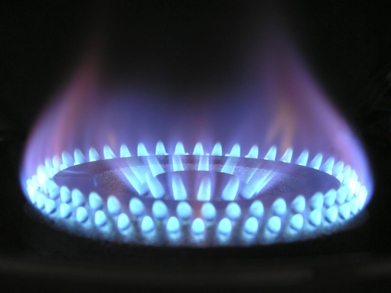 Primer plano de una estufa de gas encendida con llamas azules.