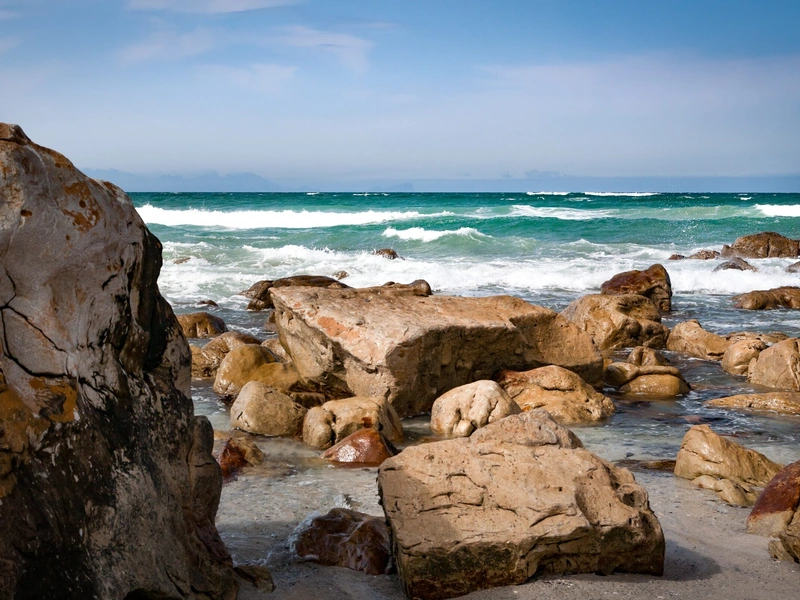 La costa rocosa con grandes rocas tiene olas que chocan contra las rocas.