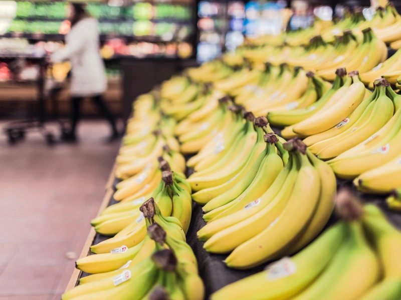 Un expositor de supermercado con hileras de plátanos de color amarillo brillante