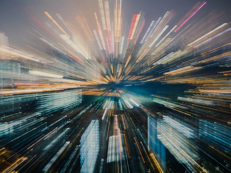 El paisaje urbano con un efecto de desenfoque del zoom crea una ráfaga dinámica de luces que emanan del horizonte.