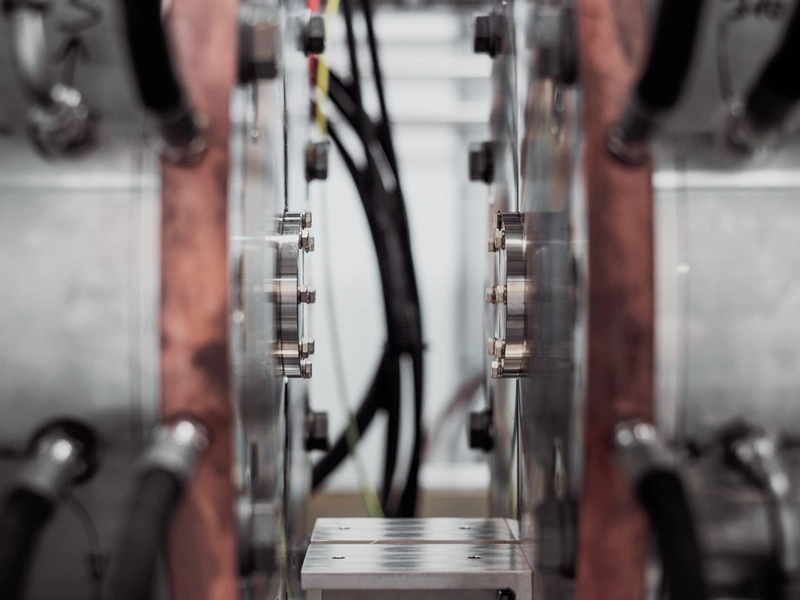 Primer plano de maquinaria industrial con componentes y cables metálicos.