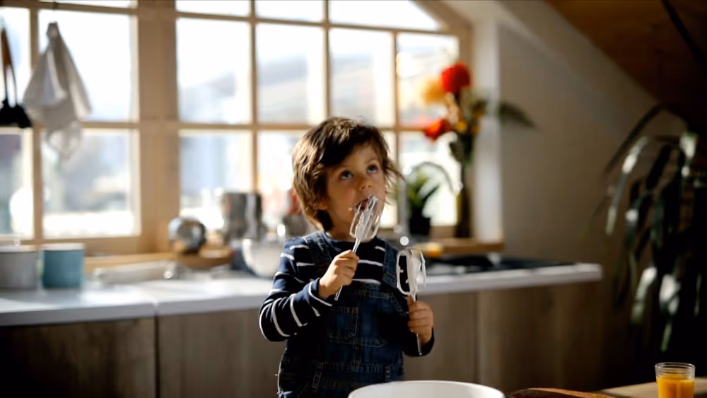 Boy licks cream from blender