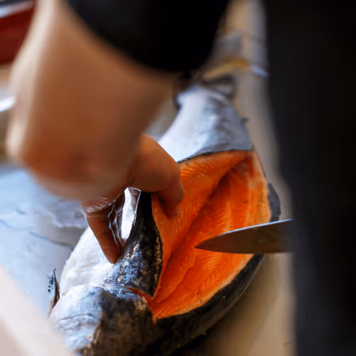 Boucher en intérim réalisant la découpe de viande en atelier de préparation