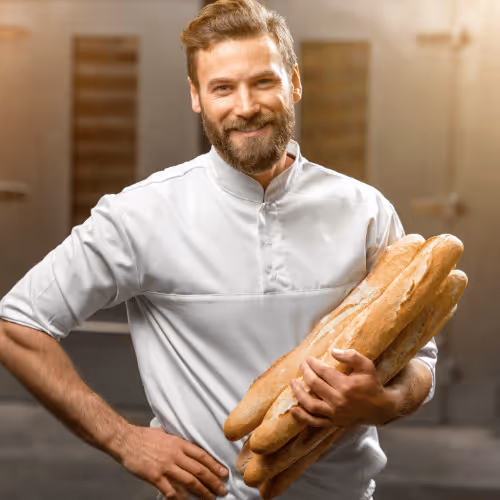 Boucher en intérim conseillant un client au comptoir boucherie en magasin