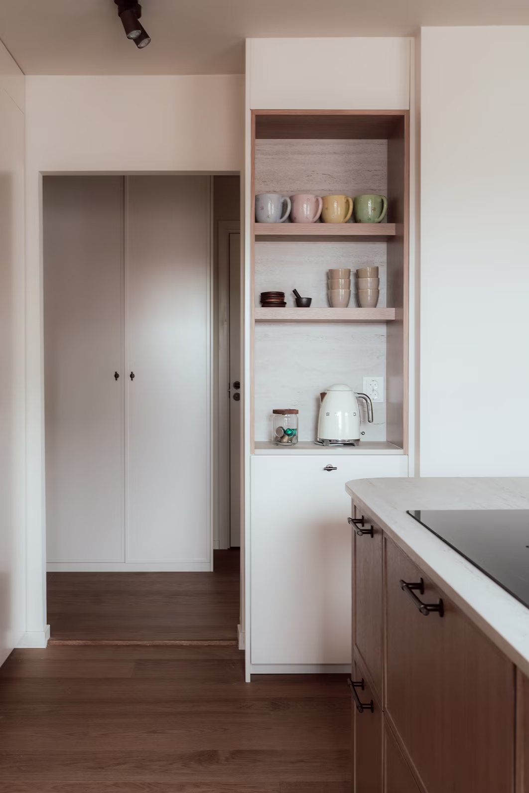 Platsbyggd hylla med stylingdetaljer och integrerad belysning i neutrala toner.