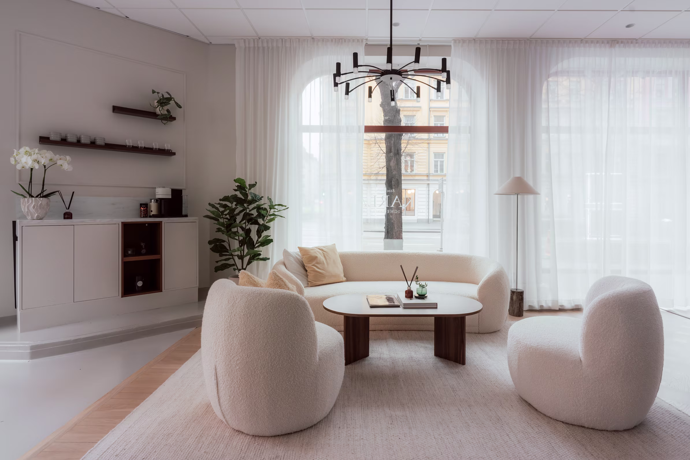 Modern kontorsmiljö på mäklarkontor med stilrena möbler, naturligt ljus och en välkomnande atmosfär för kundmöten.