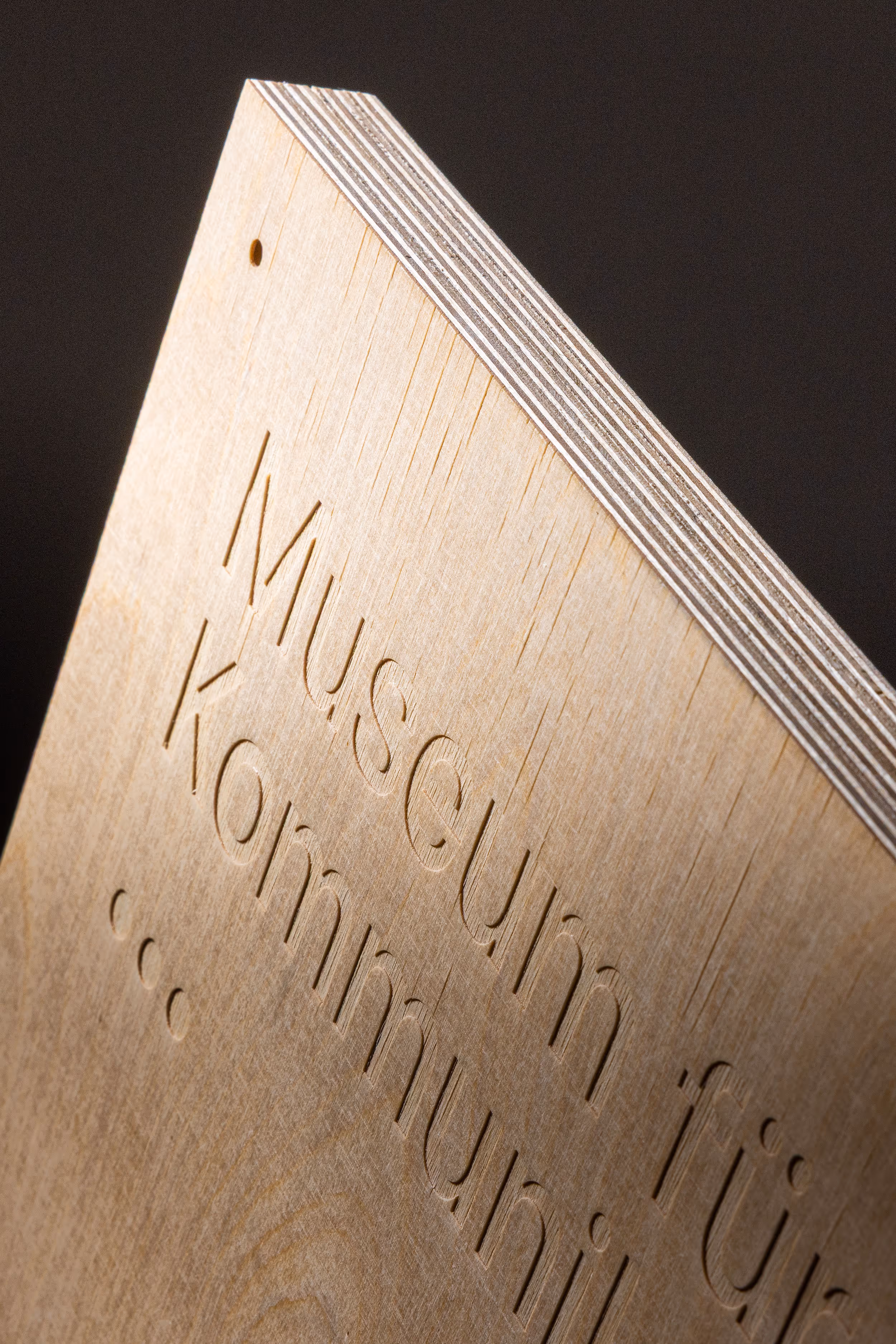 Detailaufnahme der ausgefrästen Typografie des 3D-Holzplakats für das Museum für Kommunikation
