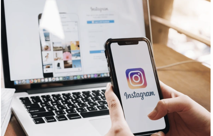instagram log in page on laptop screen and instagram logo on phone screen