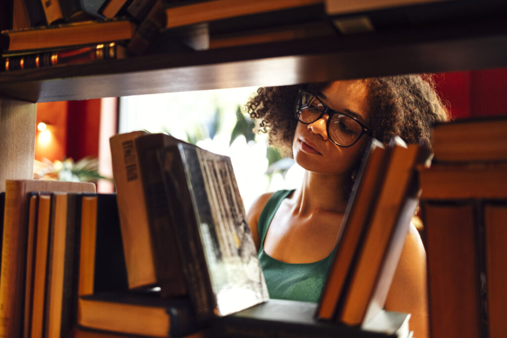 student in the university library, going through books