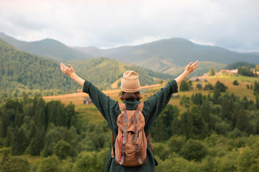 Young woman enjoying travel views by a mountain