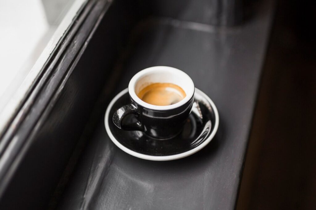 A cup of coffee left by a window