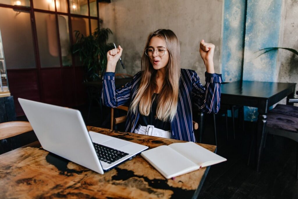 Motivated brunette woman celebrating having created great Instagram captions