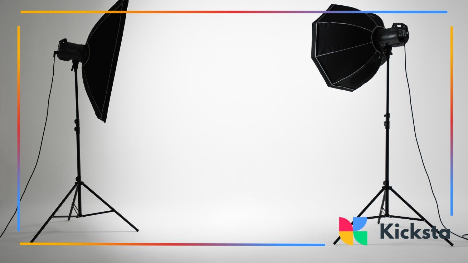 Professional photography studio setup with two large softbox lights pointed at a blank white backdrop