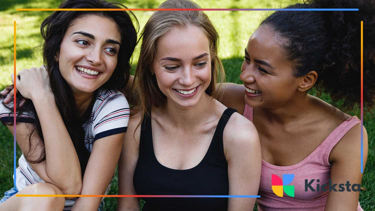 Close-up of three smiling girls sitting on the grass